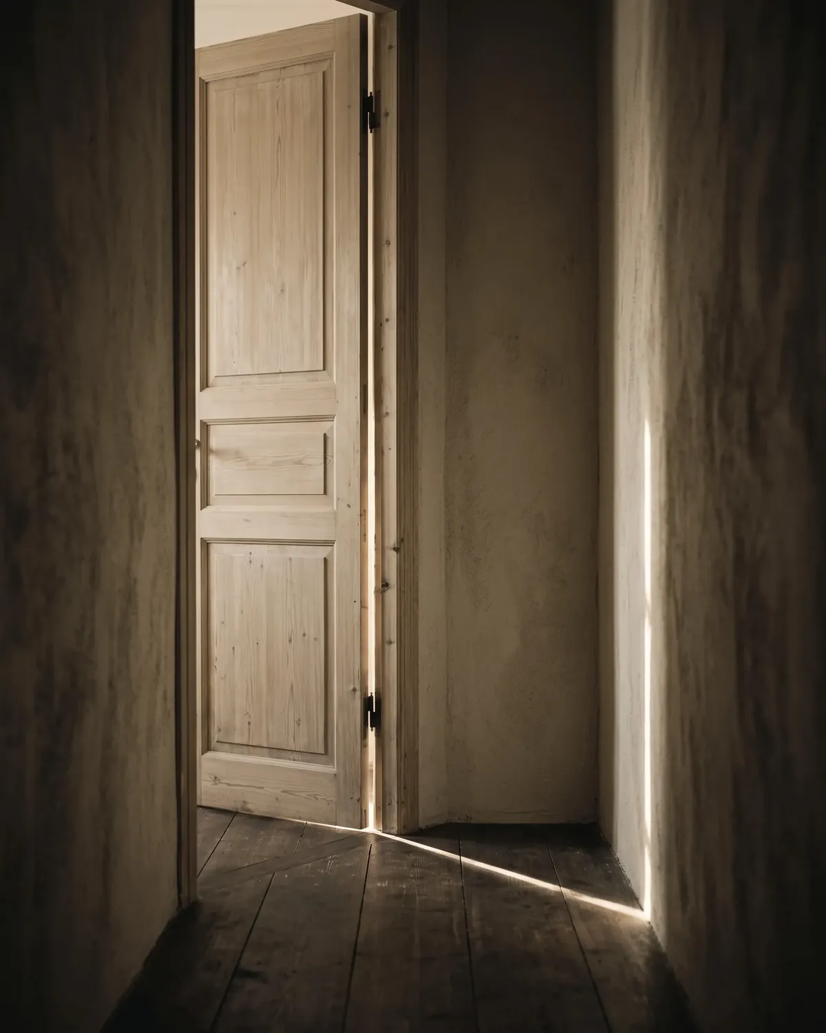 Porta socchiusa da cui entra una lama di luce
